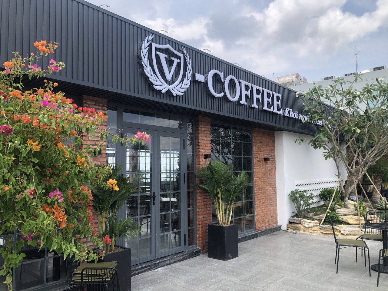 Không gian bên ngoài quán V-Coffee có cây xanh